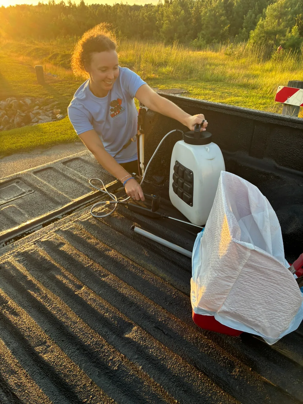 Scoop Lab team member preparing professional dog waste removal equipment at the service truck